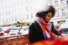 woman sitting on a bench using smart watch