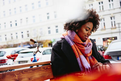 woman sitting on a bench using smart watch