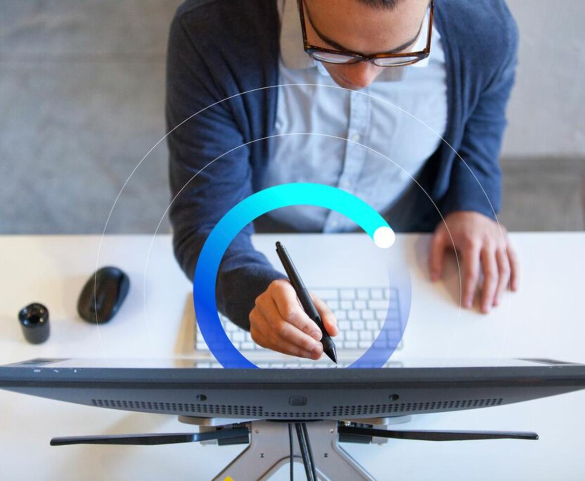 man holding stylus to touch up details on computer screen man holding stylus to touch up details on computer screen