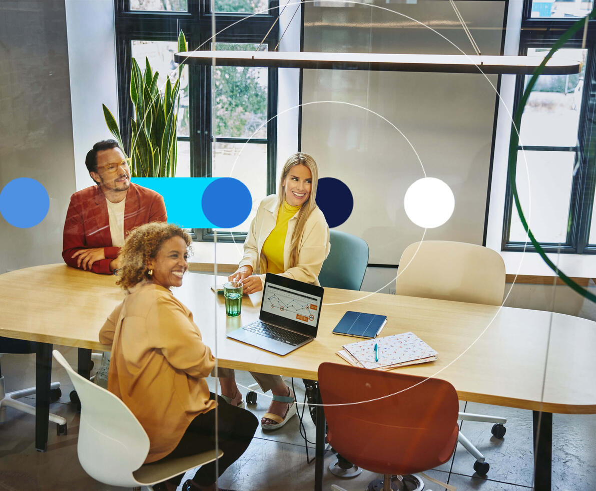 Group of people sitting at a oval table, having a meeting