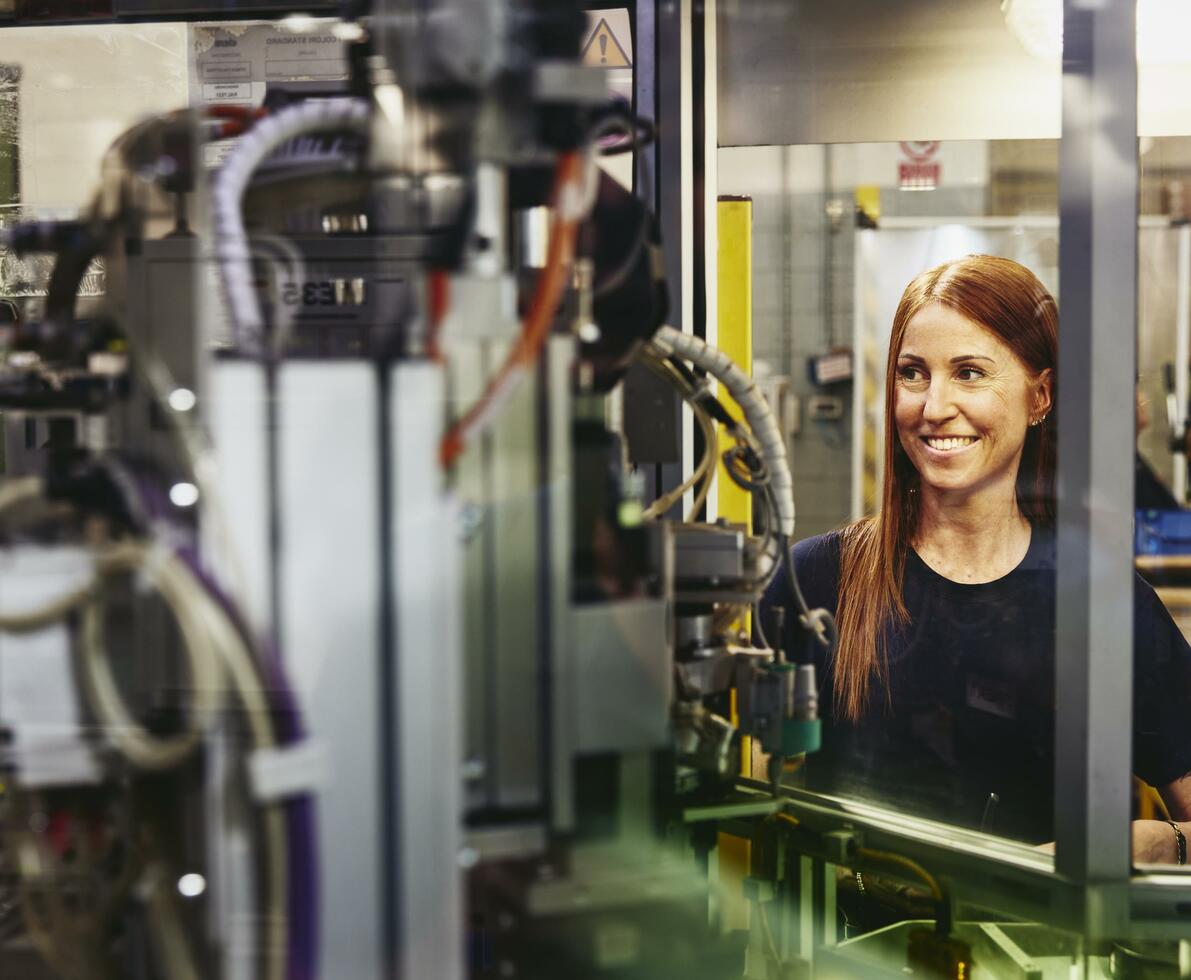 Woman operating a machine on a production site. Woman operating a machine on a production site.