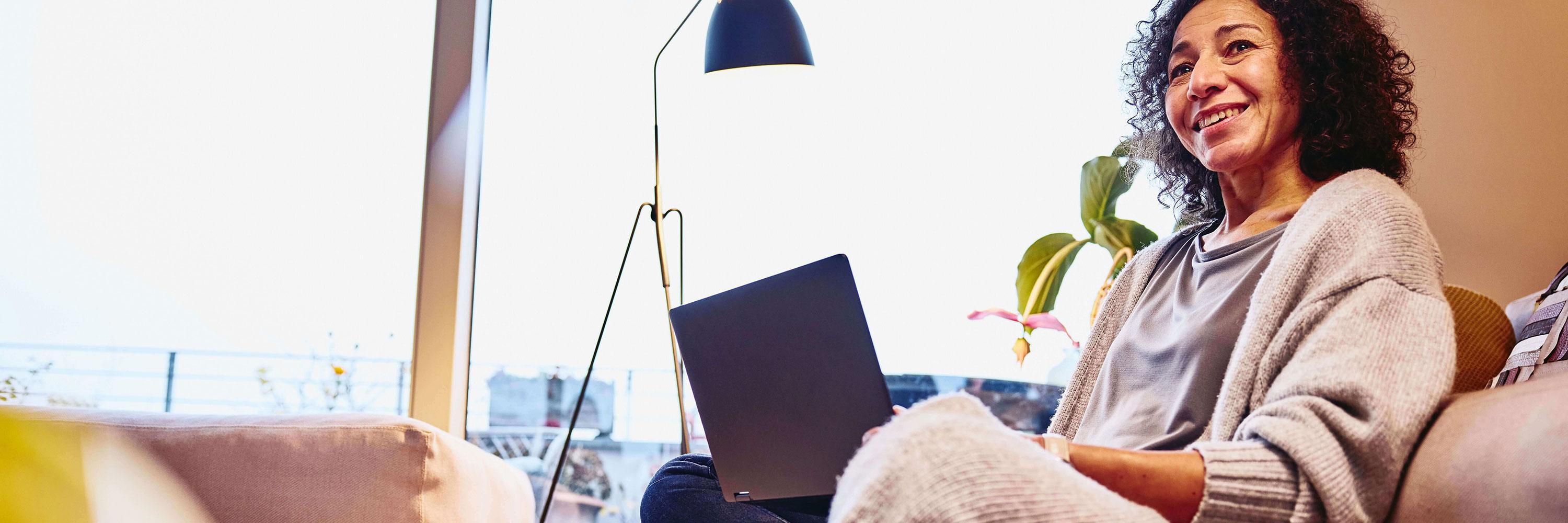 woman sitting on a couch with a laptop