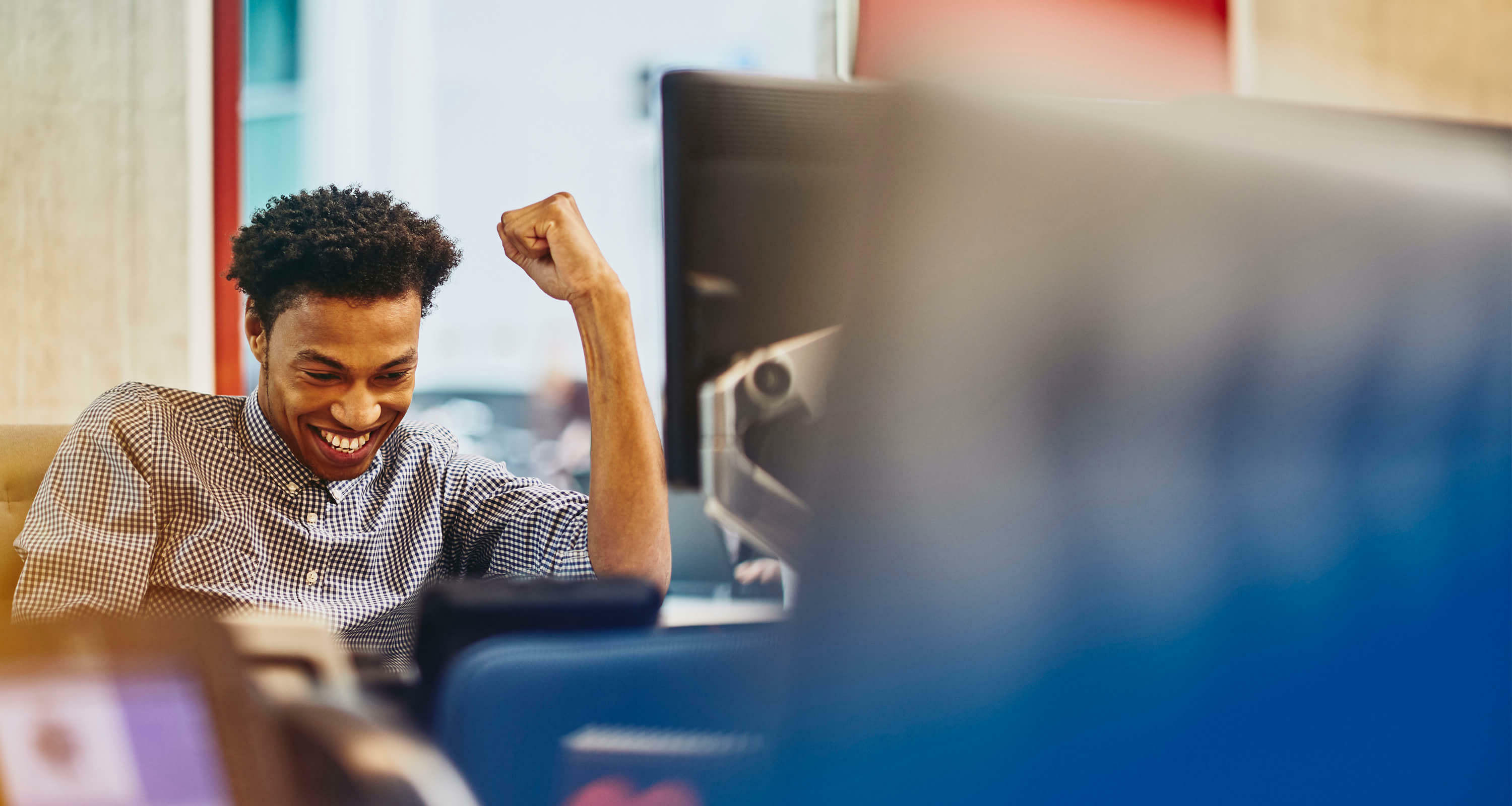 man cheering at his desk and smiling