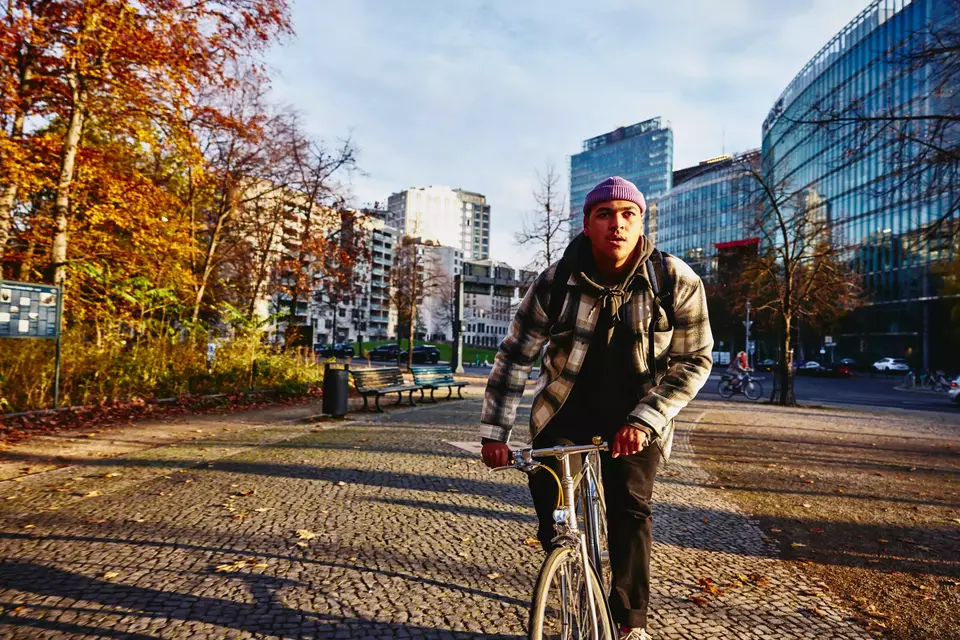 Cycling male, autumn trees and office buildings on the background.
